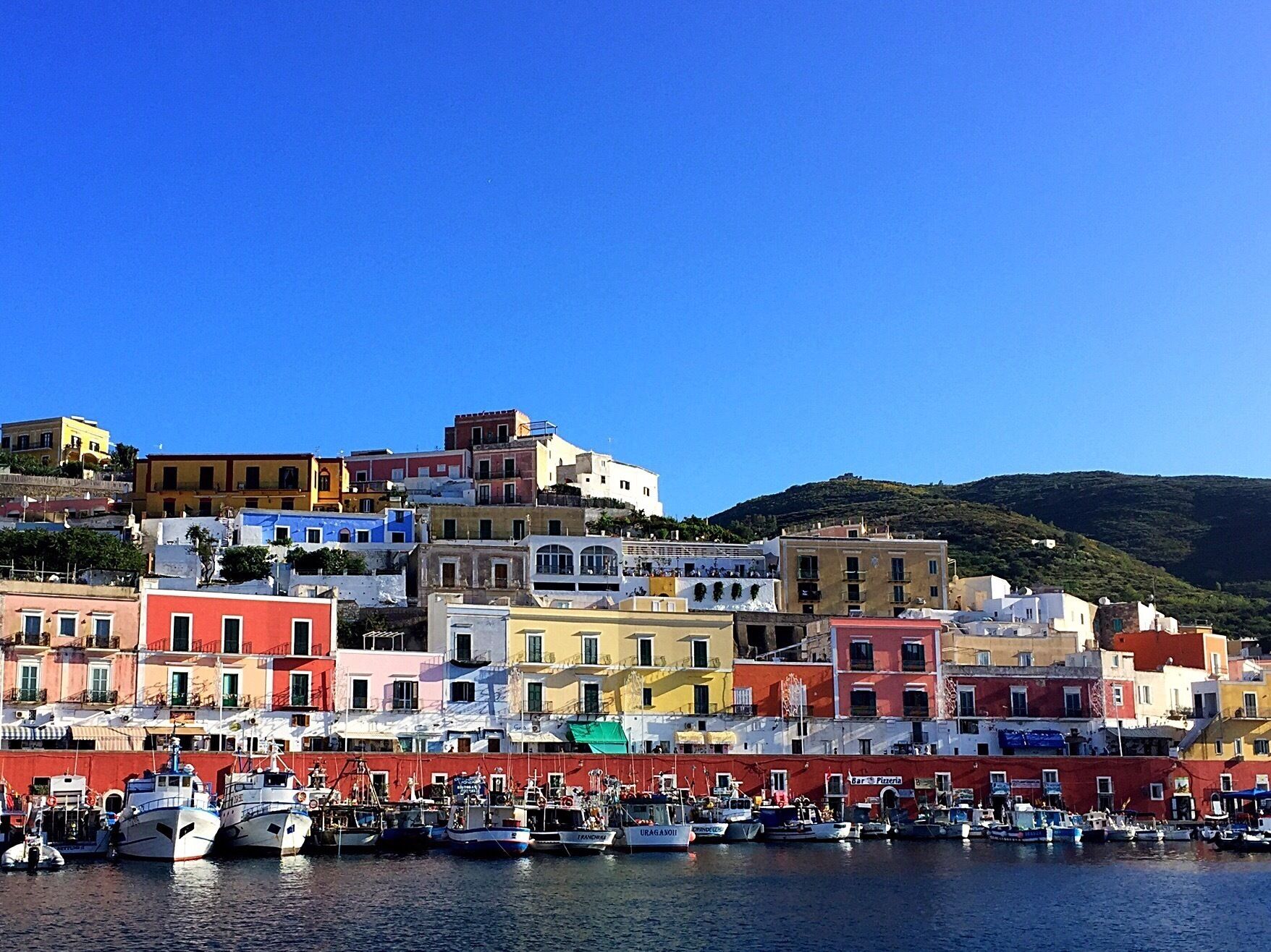 A coastal town with colorful buildings and a marina filled with boats.