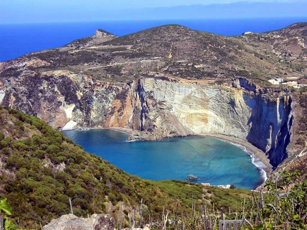 A coastal landscape with cliffs, a bay, and sparse vegetation.