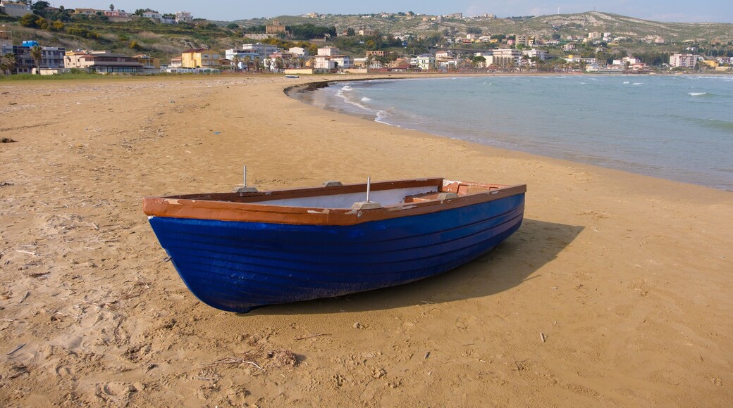 A small blue boat parked on the beach in Porto Empedocle, Sicily, under a sunny day