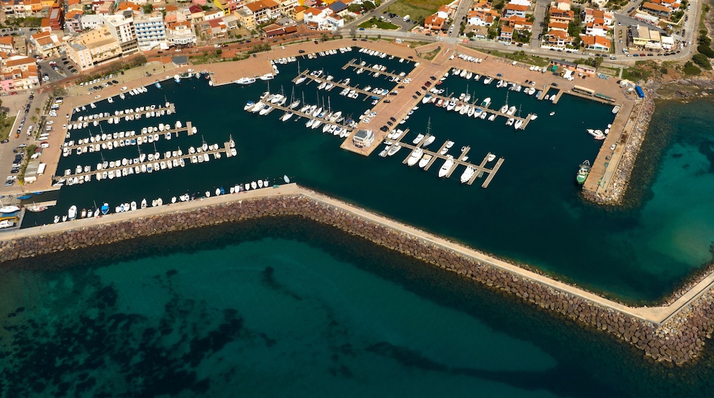 Aerial view of the marina and port of Portoscuso, in southern Sardinia, Italy. In the background the town overlooking the Mediterranean Sea. There are many boats moored at the harbour.