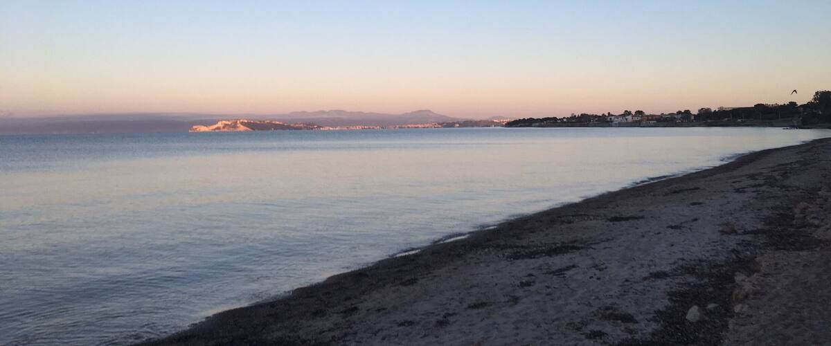 A beach with calm water and a clear sky.