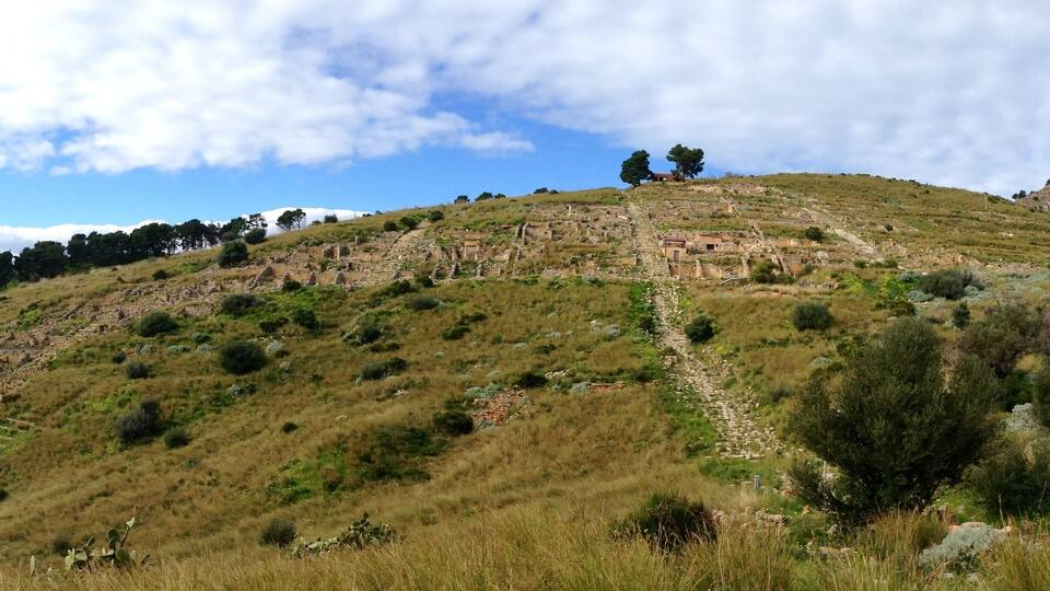 A hilly landscape with ruins and a clear sky.