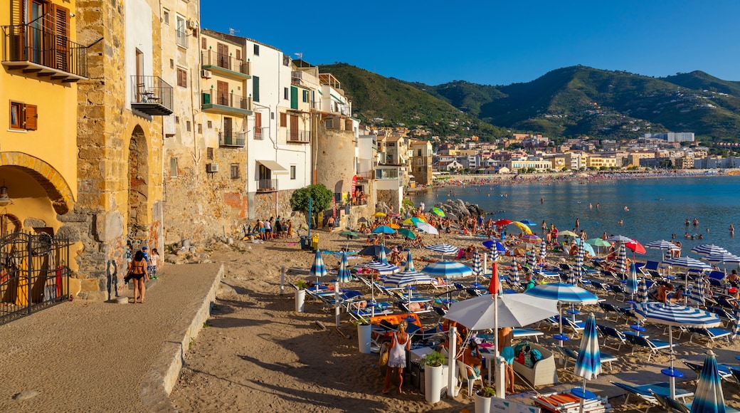 Tourists on beach, Cefalu, mountains in background, Province of Palermo, Sicily, Italy