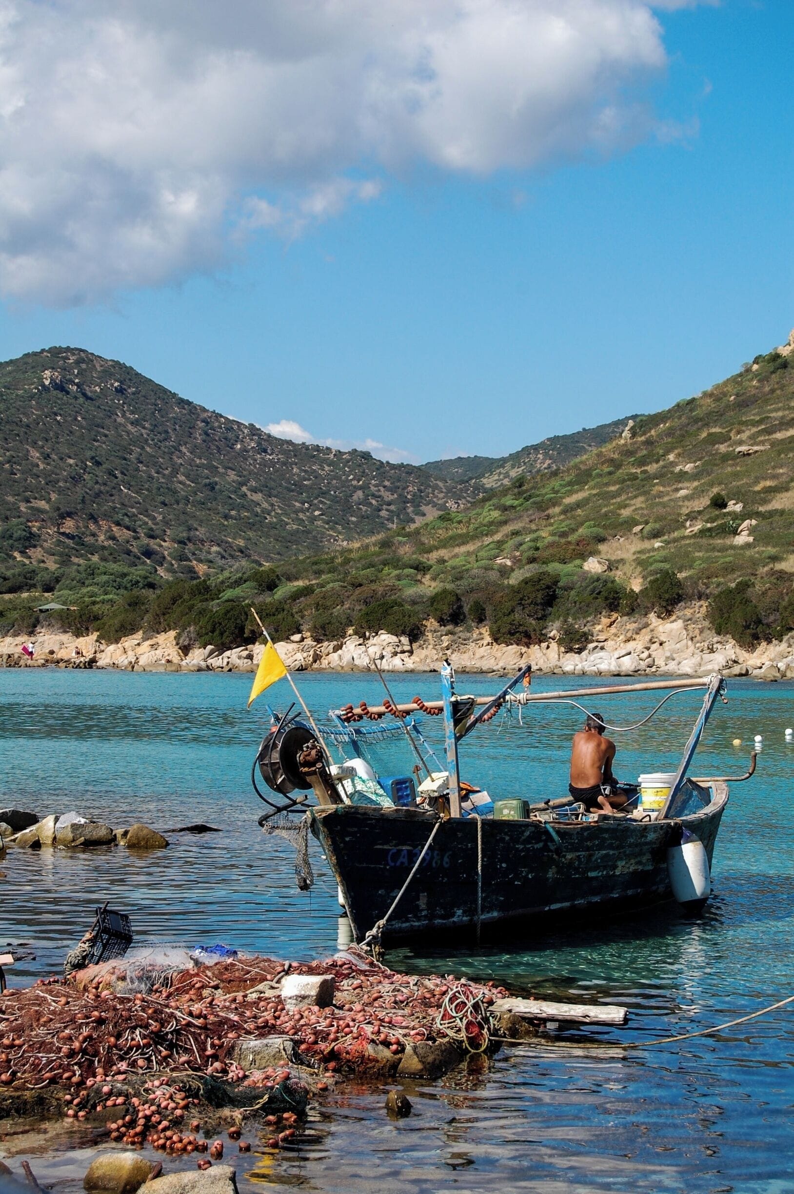 A fisherman resting in his boat on the Southeastern coast of Sardinia, between Villasimius and Costa Rei. Sardinia is easily a contender for favourite spot in the world, and this stretch of coast is dotted with flawless sandy beaches and perfectly clear water. You won't drive more than a few kilometres without finding the next one, often completely to yourself.