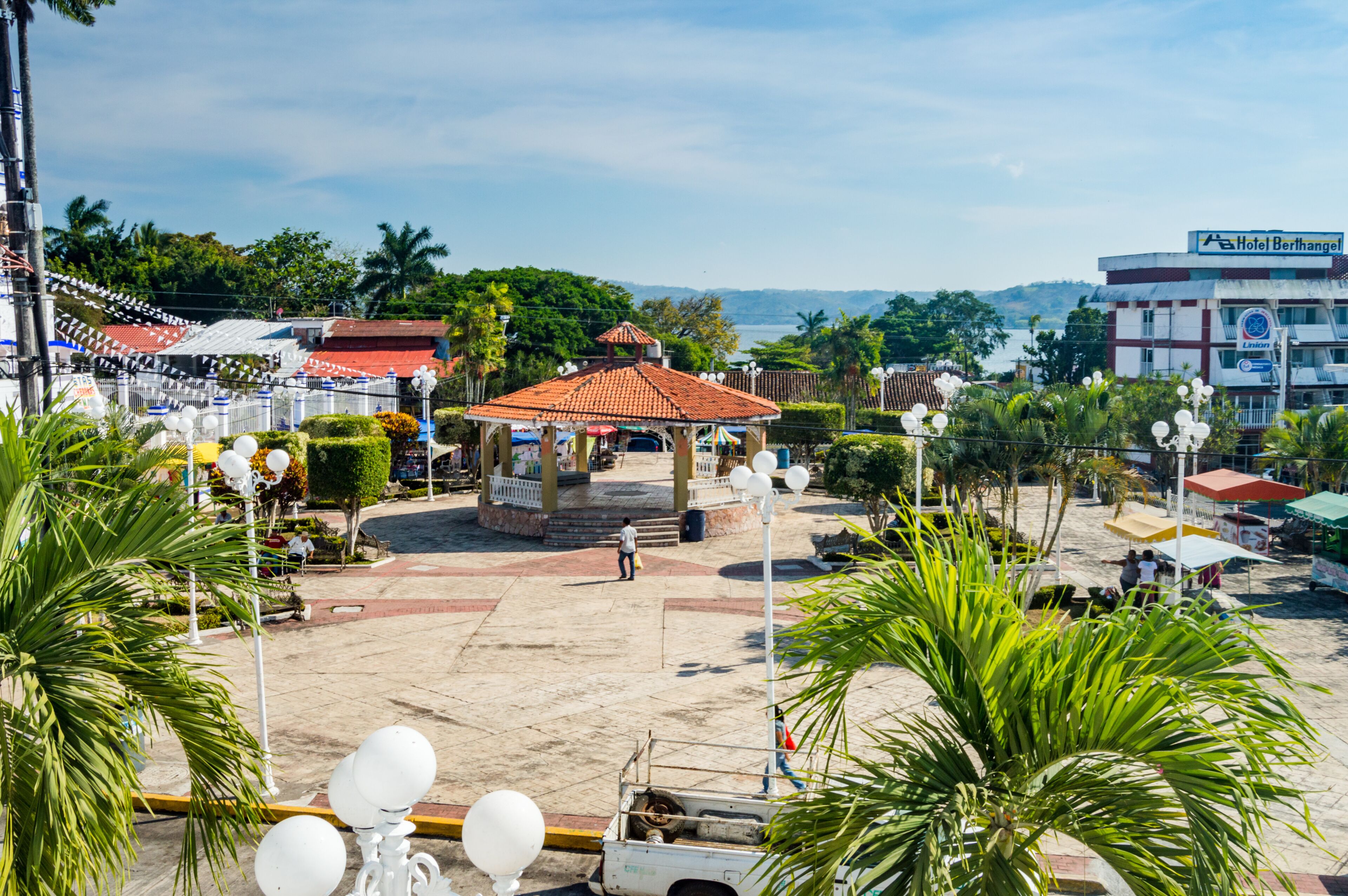 A gazebo, palm trees, a beach, and a hotel named 'Hotel Berhingel' in the background.