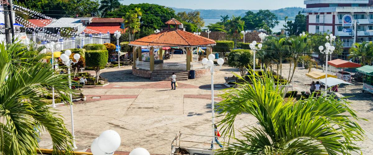 A gazebo, palm trees, a beach, and a hotel named 'Hotel Berhingel' in the background.