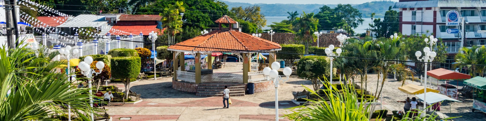 A gazebo, palm trees, a beach, and a hotel named 'Hotel Berhingel' in the background.