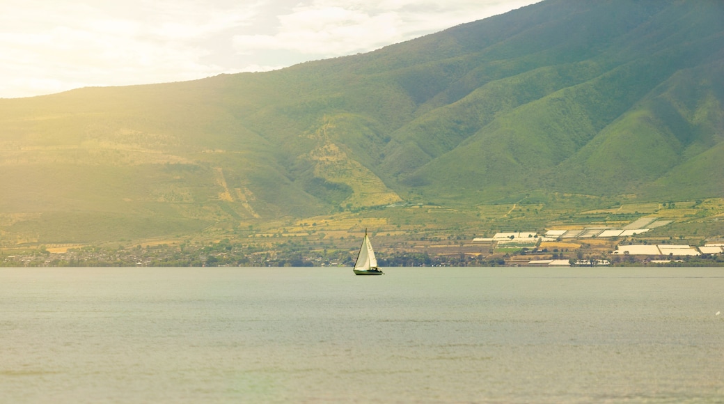 Boat in the water, scenery of mountains and sea. Feeling of grandeur, solitude.