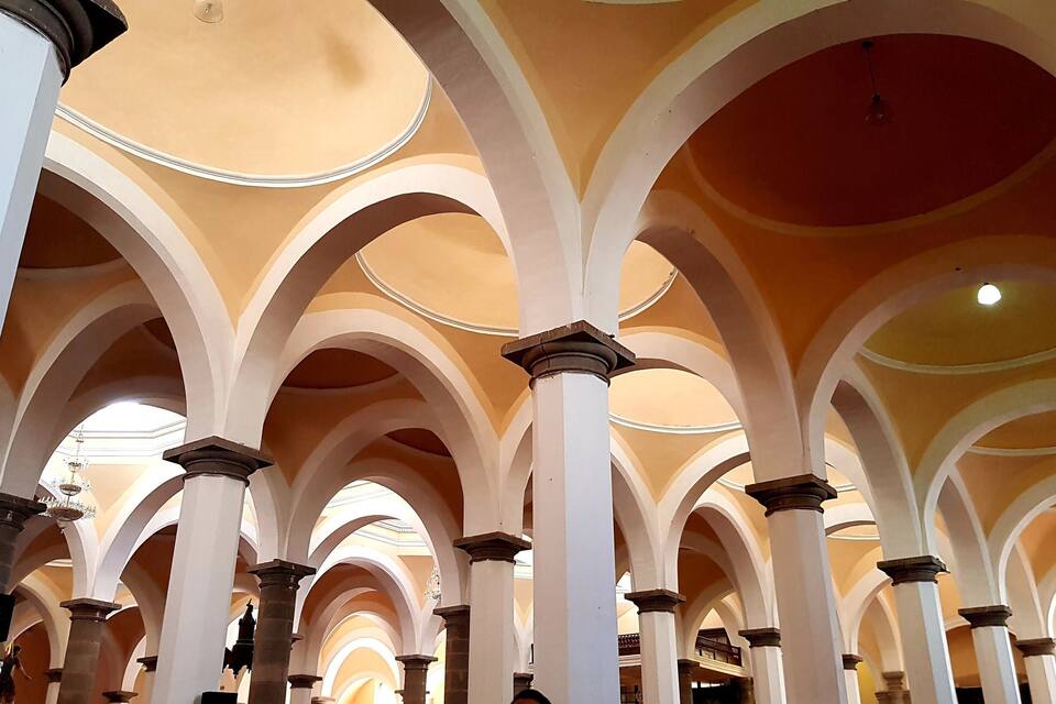 Une série d’arches surmontées d’un plafond orné de motifs.