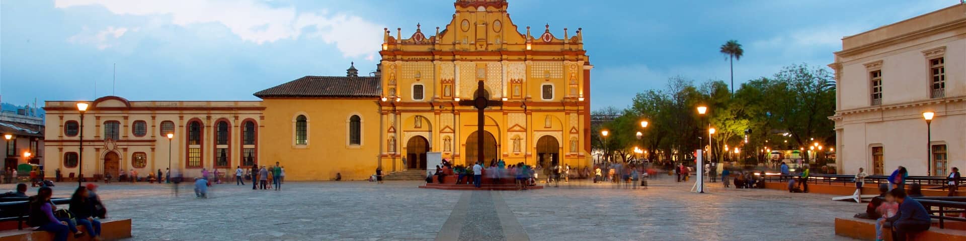 A historic plaza with a prominent church featuring ornate architecture and a central cross.