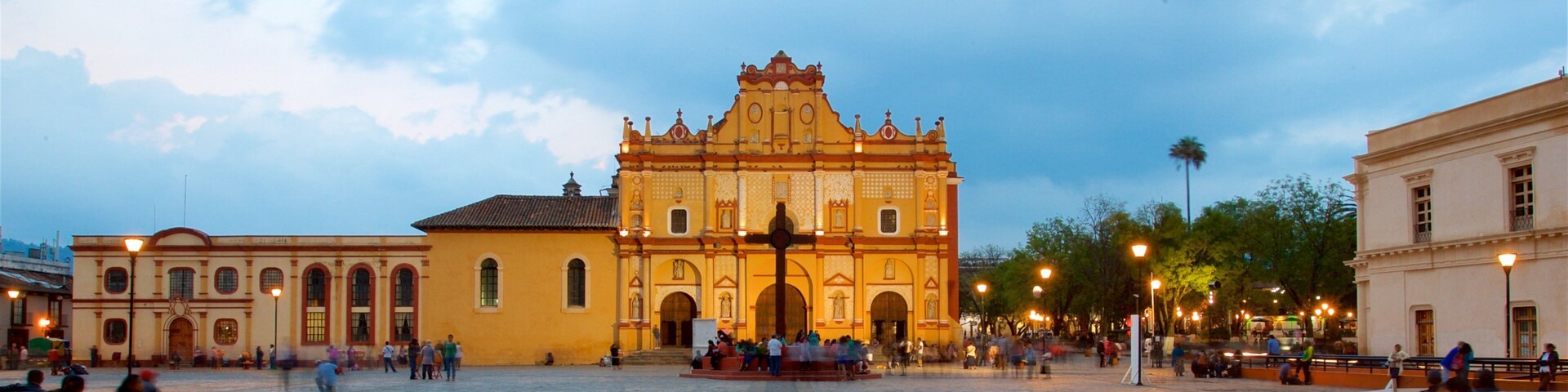 Une place historique abritant une église remarquable, caractérisée par son architecture richement décorée et une croix centrale.