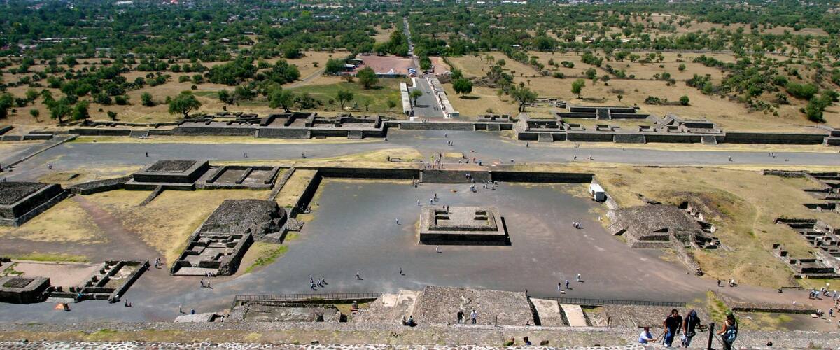An ancient archaeological site with stone structures and a large open plaza.