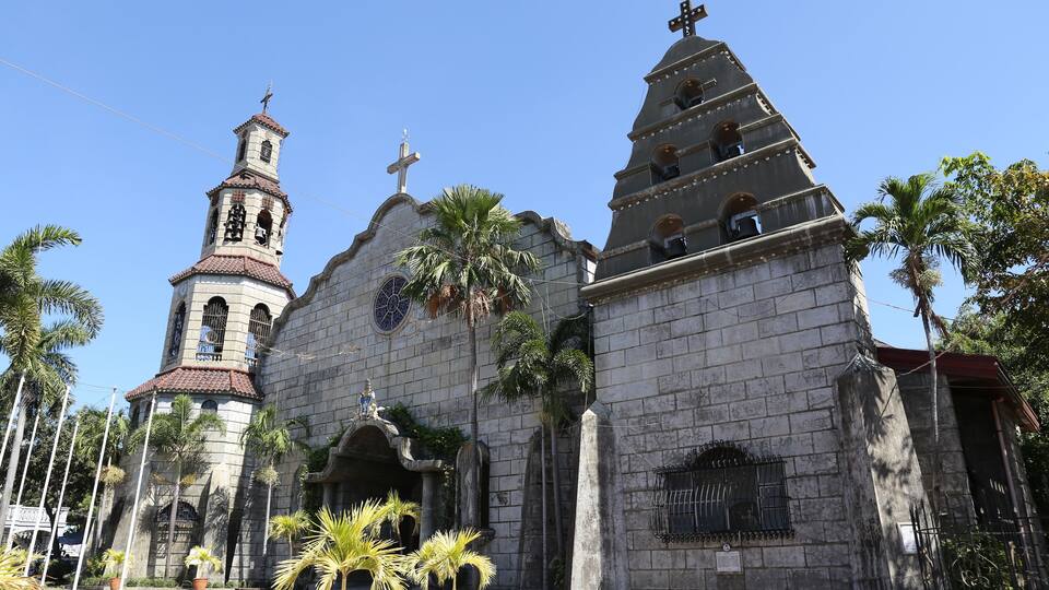 A historic church with a bell tower and a cross on top.