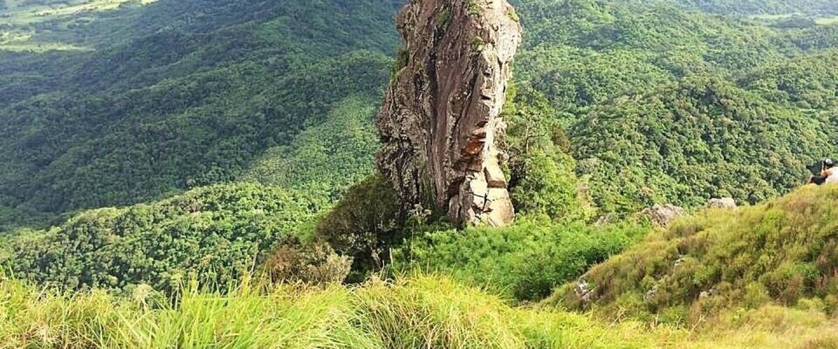 A prominent rock formation in a lush green valley.