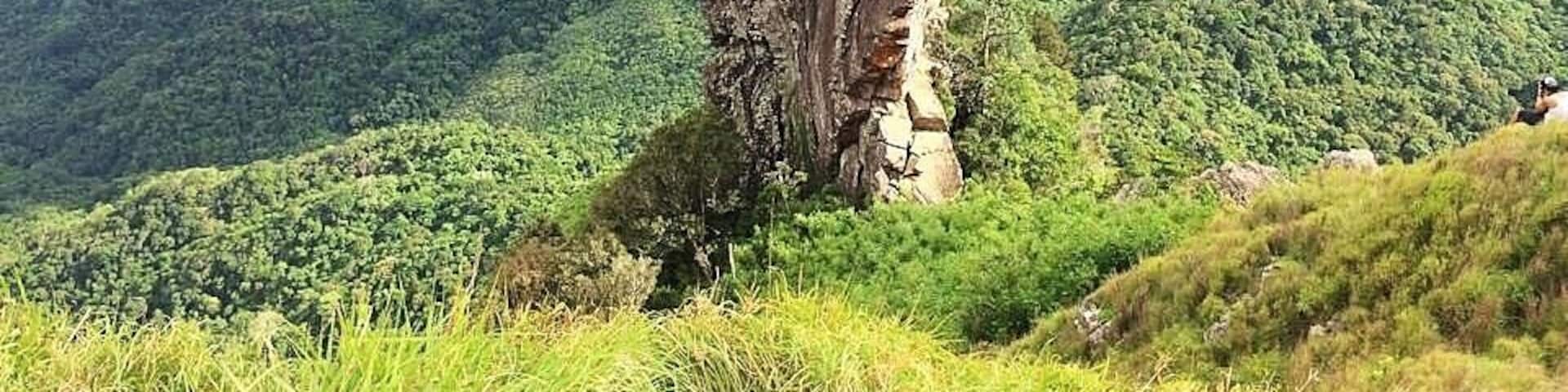A prominent rock formation in a lush green valley.