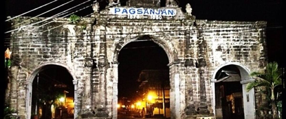 An old stone archway with the inscription "PAGSANJAN 1870-1880" at the top.