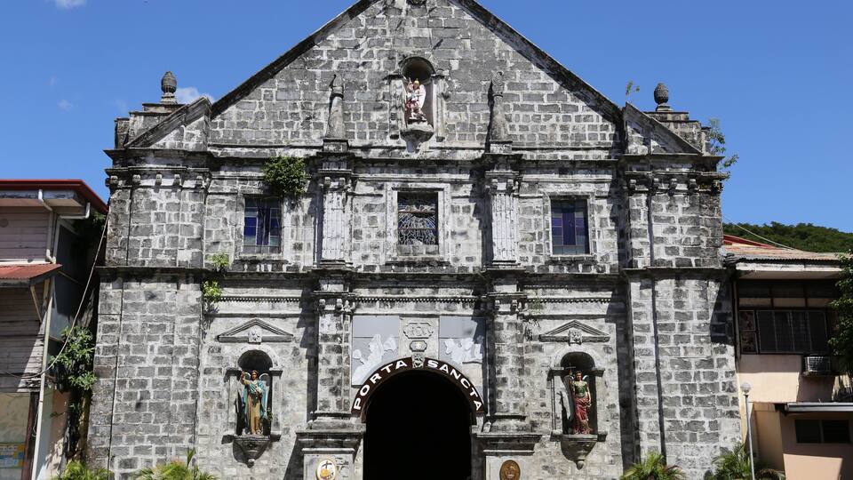 A historic stone church with a prominent entrance and statues.