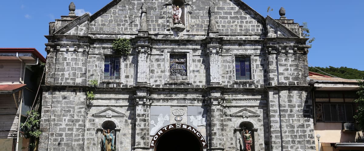 A historic stone church with a prominent entrance and statues.