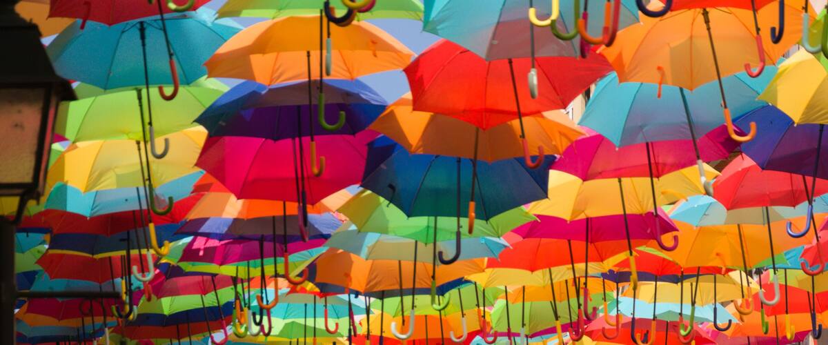 A wall of colorful umbrellas hanging in an art installation.