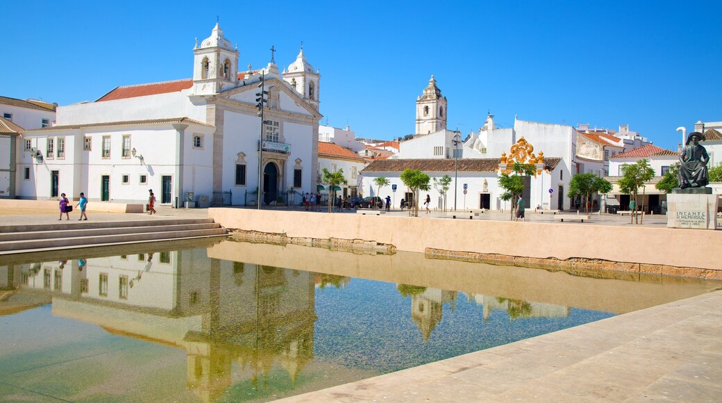 Algarve ofreciendo una pequeña ciudad o aldea, una iglesia o catedral y piscina