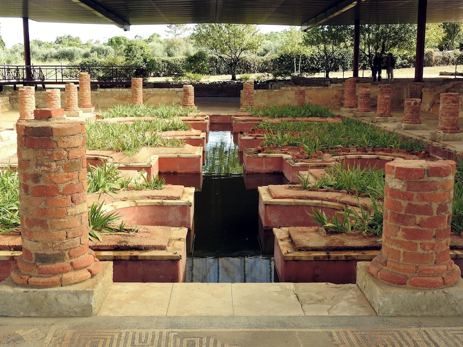A historical site with brick structures and a central water channel.