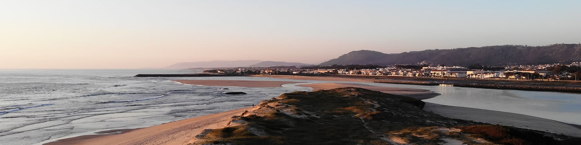 Aerial view of the Northern Litoral Natural Park in Ofir, Fao, Esposende, Portugal at sunset. The two sides of Restinga de Ofir. One facing the ocean, the other the estuary of Cávado River.