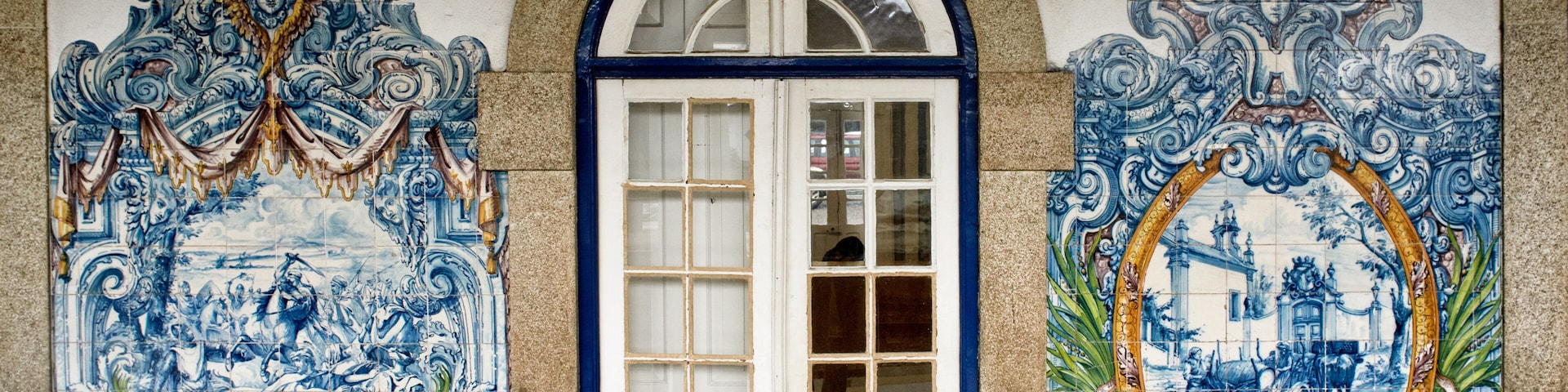 Uma porta branca com azulejos decorativos azuis em ambos os lados.