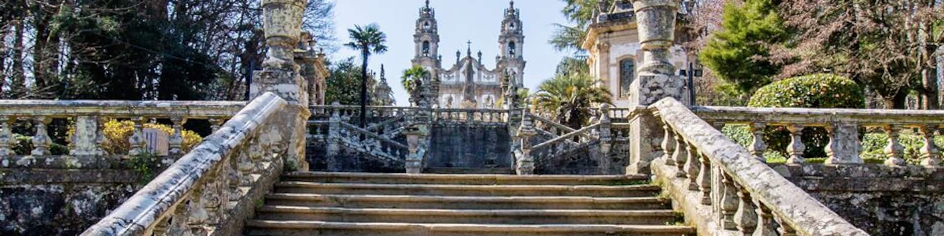Una escalera de piedra que conduce a un edificio histórico con barandales ornamentales.