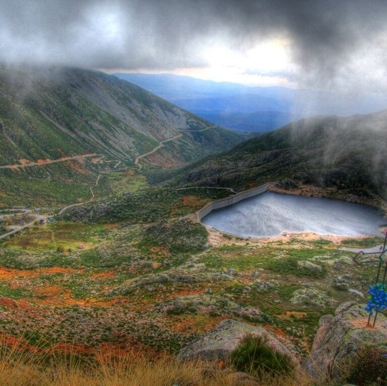 A mountainous landscape with a lake and a winding road.