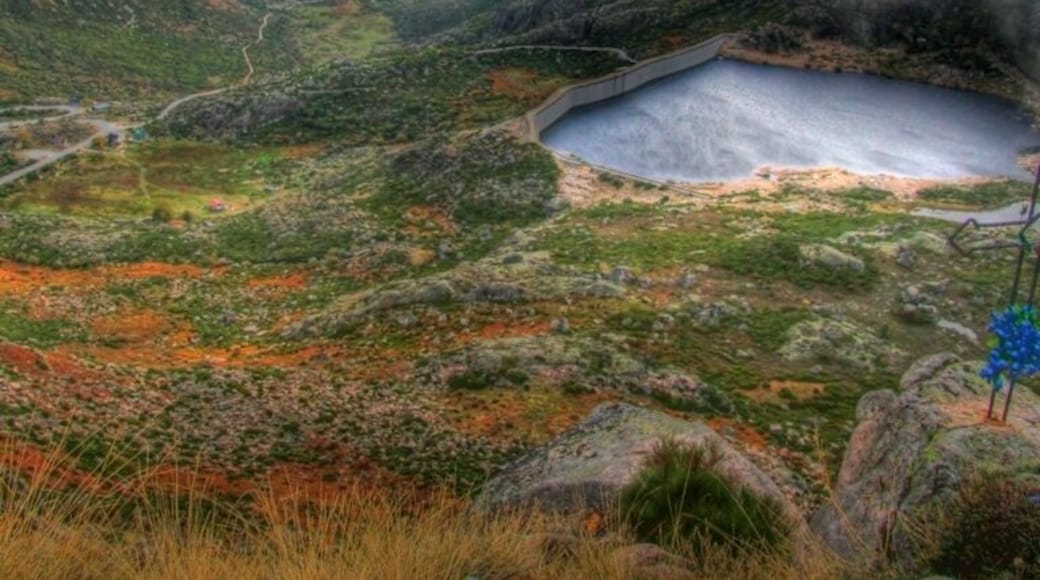 A mountainous landscape with a lake and a winding road.