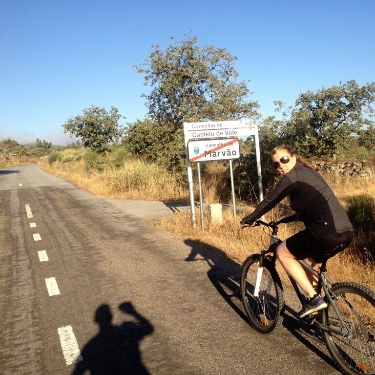 A cyclist on a road with a sign indicating Marvão.