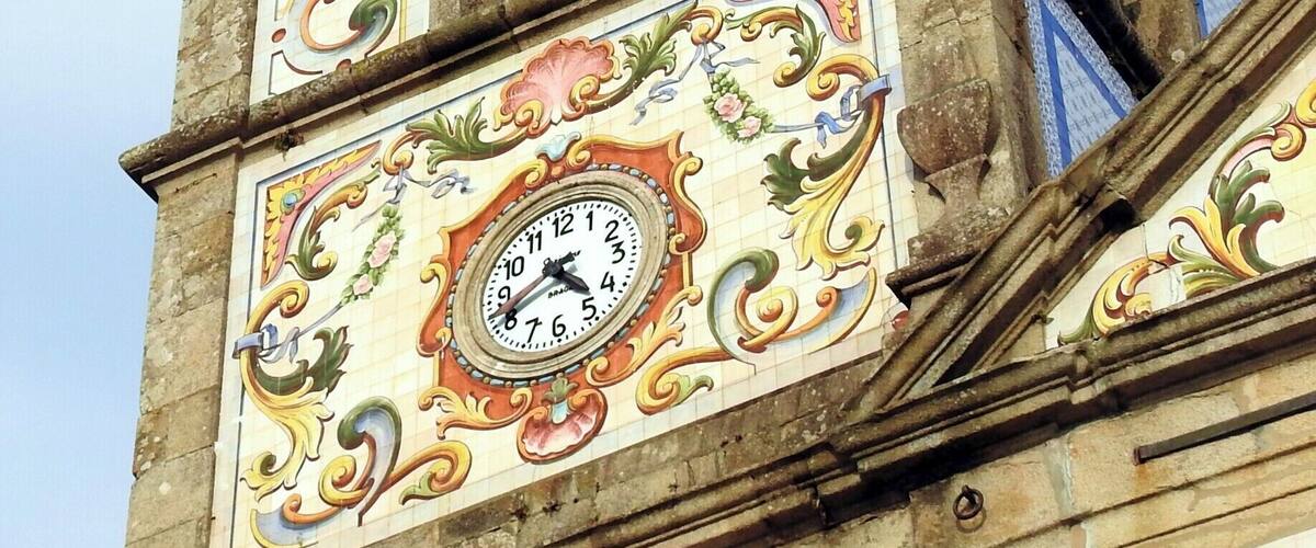 Une tour de l’horloge ornée de décorations raffinées et surmontée d’une cloche.