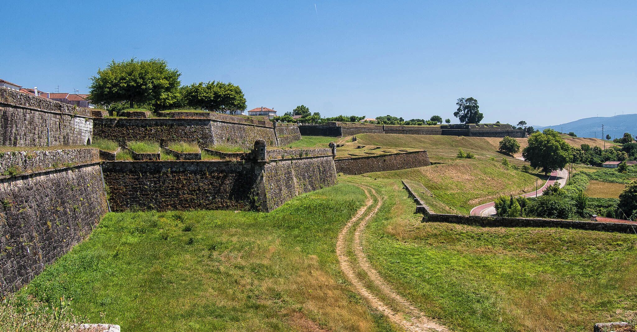 A historic stone fortification with a dirt path leading through it.