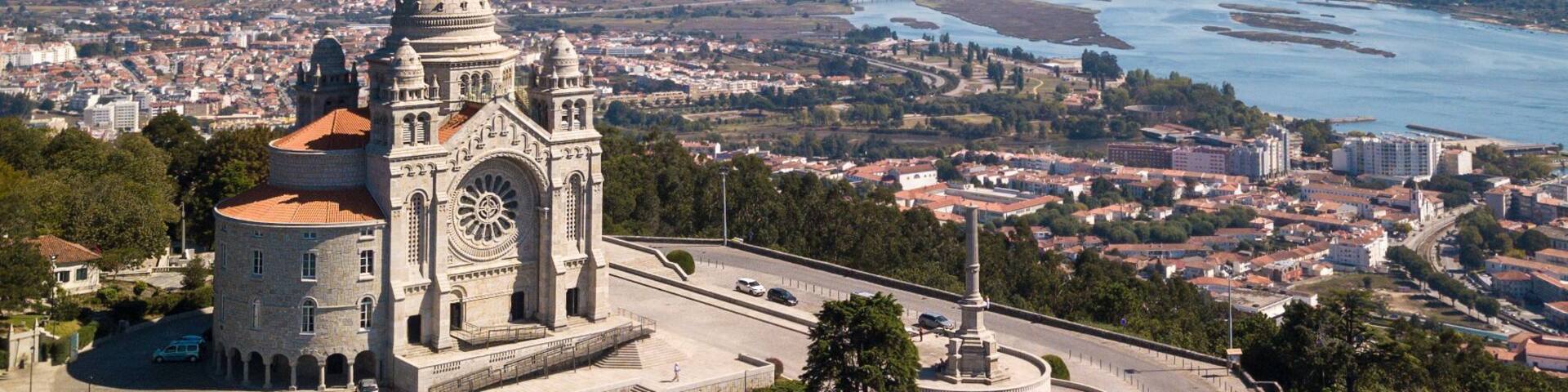 A historic cathedral with a prominent dome and bell tower, surrounded by a fortified wall and overlooking a river and cityscape.
