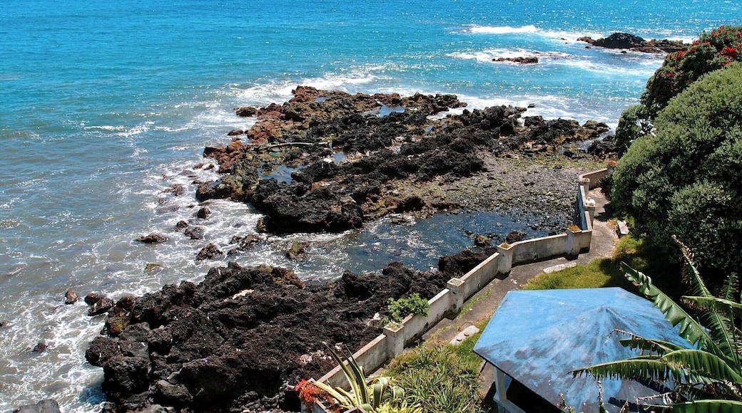 A #blue roof in an oceanside garden on the island of São Miguel in the Azores Archipelago; Ilhéu da Vila Franca sits on the horizon, a beautiful swimming hole in a volcanic crater.