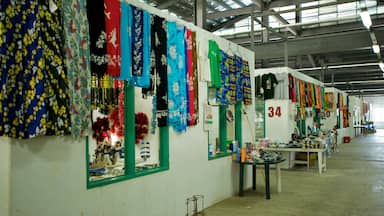 Mercado com tecidos e artigos têxteis coloridos expostos em estantes.