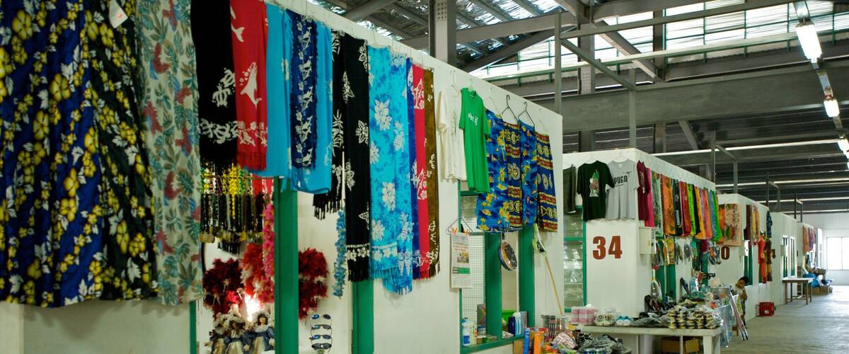 A market with colorful fabrics and textiles displayed on racks.