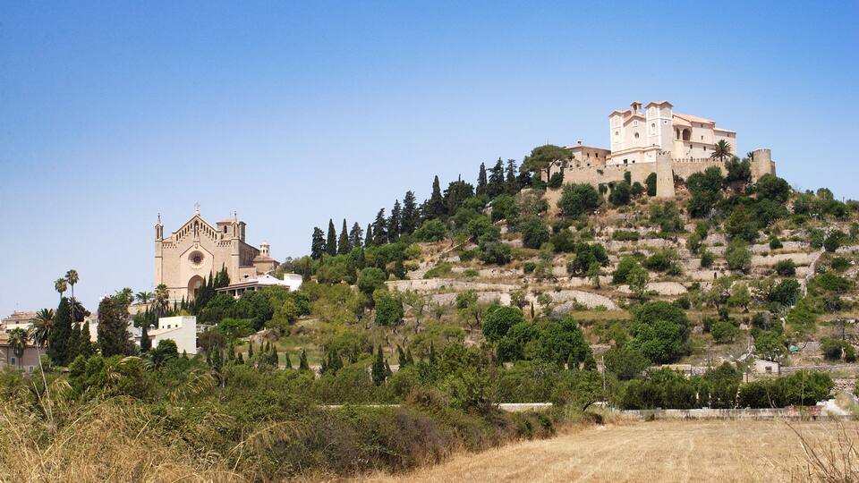 A hilltop with a church and a castle-like building.