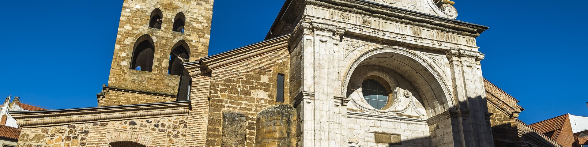 A historic stone church with a bell tower and a large arched entrance.