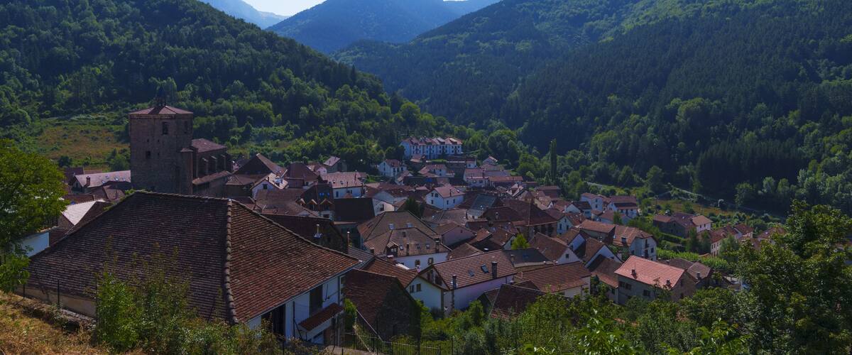 A village nestled in a valley surrounded by mountains.