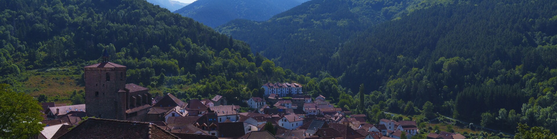 A village nestled in a valley surrounded by mountains.
