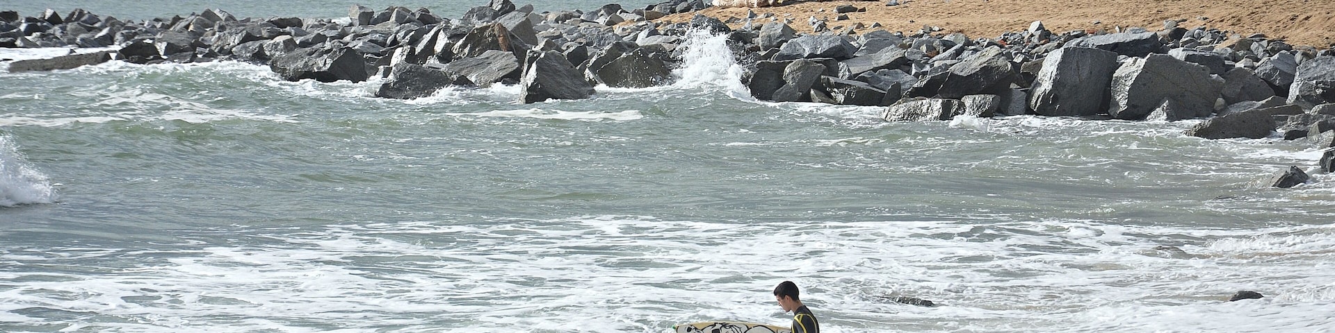 A rocky beach with waves crashing onto the shore.