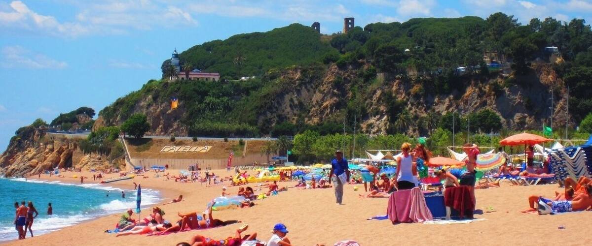 Beautiful clean white sand for miles and crystal clear turquoise water. Parties & bars on the beach, some free concerts in the summer time. You can hike up into the hill here, there are some old ruins up there, you can see peeking out from the trees in this photo. 
Apparently since the 70's, Calella, was a booming tourist destination for Western Europeans and the British. It has been on a massive decline over the past decade. What's left behind though are some fun Dutch and English/Irish pubs, a small welcoming expat community, and one of the most incredible beaches you will ever lay your eyes on. 
If you happen to find yourself here, you must stop in at Beach Boys Club, tell the owners, Brian & Cathy, that Amber sent you. Then hit up Brian for his secret stash of American imported Budweiser (Did you know the bottled stuff is always produced in country? Brian believes the secrets in the water, so he gets the cans from the US. Brian is British, which makes this little story even better.)
Also, be prepared to eat a lot of rotisserie chicken.