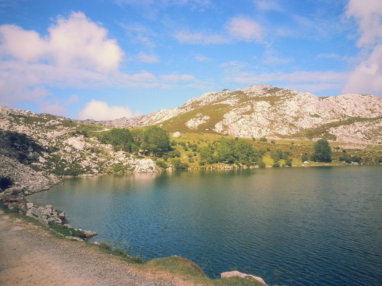 Un lago rodeado de montañas rocosas y vegetación escasa.