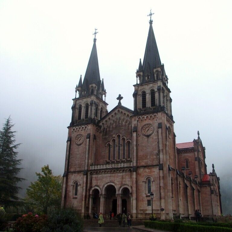 A historic church with two tall spires and a clock tower.