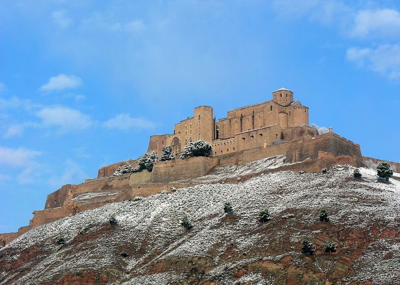 A snow-covered hill with a historic building on top.
