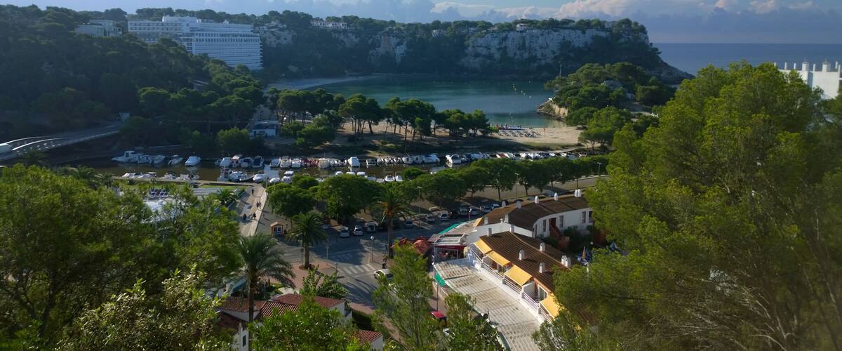 A coastal town with a marina, beach, and cliffside buildings.