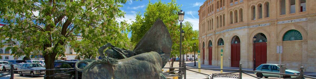 Eine Bronzestatue eines Stiers in einem Springbrunnen, im Hintergrund ein Gebäude.