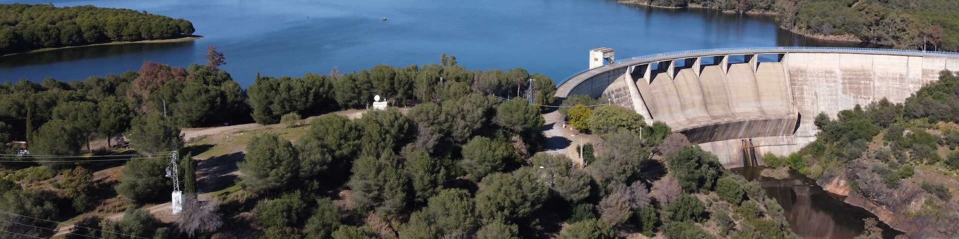 Dam of El Gergal surrounded by greenery under the sunlight in Guillena, Spain