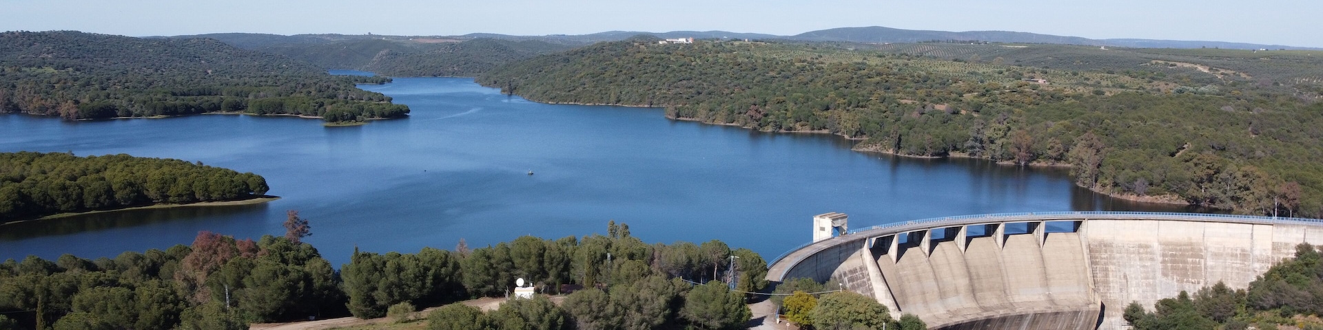 Dam of El Gergal surrounded by greenery under the sunlight in Guillena, Spain